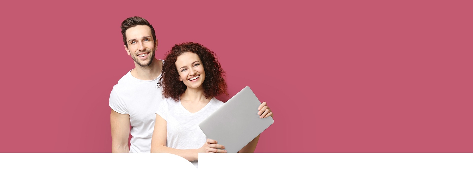 Een jong stel kijkt elkaar aan en de jonge vrouw houdt een laptop vast op een rode achtergrond